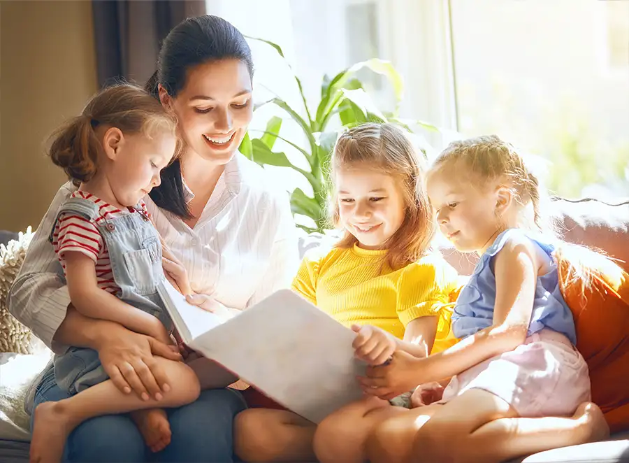 mother and her three daughters reading a book together Decatur, Illinois